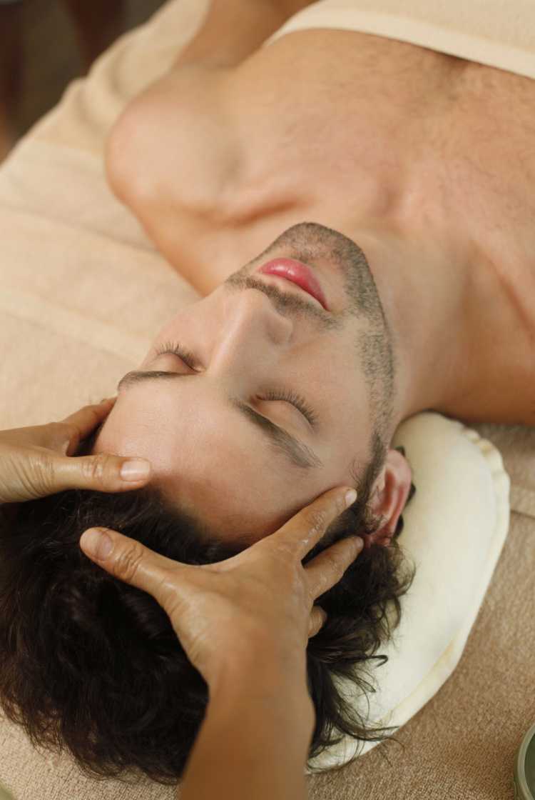 massage therapist massaging man's head